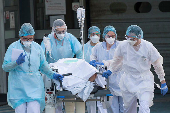 Coronavirus de Wuhan. Le personnel médical pousse un patient sur un brancard vers un hélicoptère médical en attente à l'hôpital Emile Muller de Mulhouse. (Photo : SEBASTIEN BOZON/AFP via Getty Images)