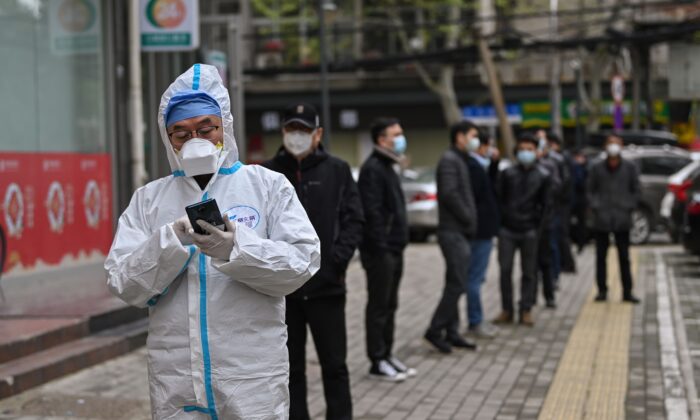 Des personnes attendent de subir un test de dépistage du virus du PCC à Wuhan, dans la province centrale du Hubei, en Chine, le 30 mars 2020. (Hector Retamal/AFP via Getty Images)