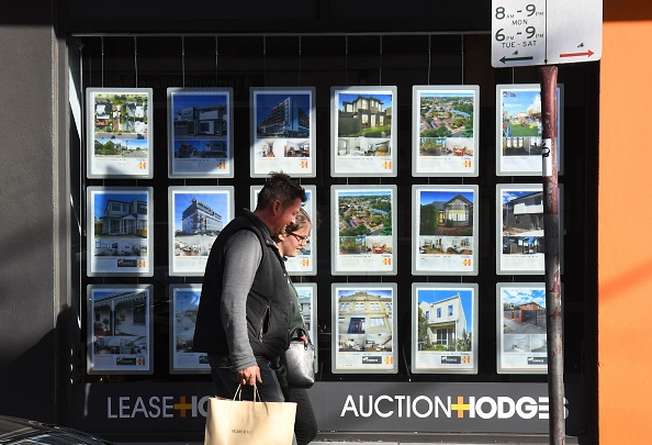-Illustration- Un couple passe devant les vitrines d'un agent immobilier à vendre. Photo de William WEST / AFP WEST / AFP via Getty Images.