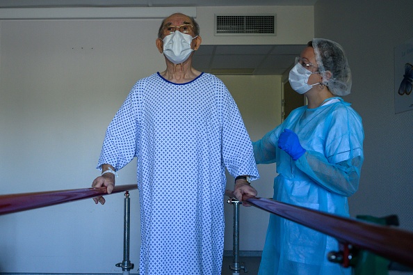 -Un physiothérapeute prend en charge un patient en réadaptation alors qu'il se remet d'une infection par le nouveau coronavirus COVID-19, dans un hôpital d'Illkirch-Graffenstaden, dans l'est de la France, le 14 avril 2020. Photo de PATRICK HERTZOG / AFP via Getty Images.