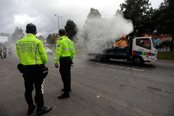 -Un camion de l'entreprise de nettoyage désinfecte le point de contrôle des véhicules pendant le verrouillage ordonné par le gouvernement le 4 mai 2020 à Quito, Équateur. Photo de Franklin Jacome / Getty Images.