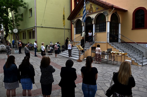 -Des fidèles orthodoxes se tiennent devant une église à Thessalonique le 17 mai 2020, les églises en Grèce rouvraient après une fermeture de deux mois visant à enrayer la propagation du COVID-19. Photo de Sakis MITROLIDIS / AFP via Getty Images.