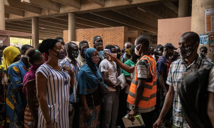 Un agent communal mesure la température corporelle des commerçants à l'ouverture du grand marché de Rood Wokos à Ouagadougou, au Burkina Faso, le 20 avril 2020, après que le marché a été fermé depuis le 25 mars 2020, à titre de mesure préventive contre la propagation du Covid-19. (Olympia de Maismont/AFP via Getty Images)