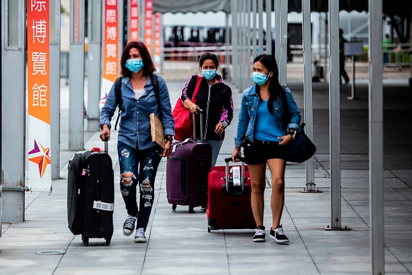 -Illustration- Des passagers aériens quittent un centre de contrôle installé à l'AsiaWorld-Expo pour les passagers arrivant à Hong Kong le 18 avril 2020. Photo par ISAAC LAWRENCE / AFP via Getty Images.