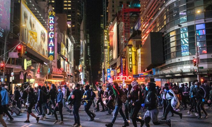 Les manifestants se précipitent devant Times Square après 23 heures alors que le couvre-feu a commencé à New York le 1er juin 2020. (John Moore/Getty Images)