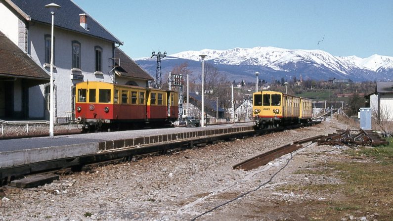 Deux trains de la Ligne de Cerdagne à la gare de Bourg-Madame (Pyrénées-Orientales, France) - Wikipédia - Par trams aux fils. — originally posted to Flickr as Trains de Cerdagne, CC BY 2.0, https://commons.wikimedia.org/w/index.php?curid=10797759
