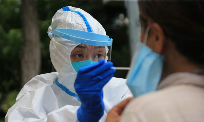 Un professionnel de la santé effectue un test sur le Covid-19 à Dalian, dans la province du Liaoning, au nord-est de la Chine, le 26 juillet 2020. (STR/AFP via Getty Images)