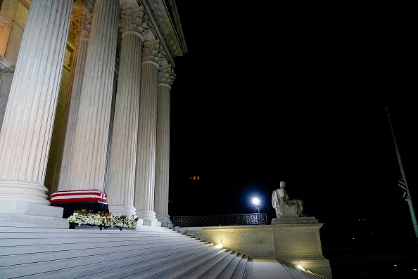 -Le cercueil drapé de la juge Ruth Bader Ginsburg repose sous le portique en haut des marches du bâtiment de la Cour suprême américaine à Washington, DC, le 23 septembre 2020. Photo par Andrew Harnik / POOL / AFP via Getty Images.