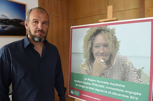 Sébastien Chadaud-Pétronin pose à côté d'une photo de sa mère française otage Sophie Pétronin. (MEHDI FEDOUACH/AFP via Getty Images)