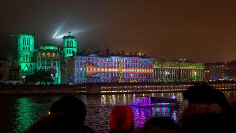 Illuminations projetées sur la cathédrale Saint-Jean Baptiste (g) depuis l'autre rive de la Saône lors de la 21e édition de la fête des Lumières, à Lyon, dans le centre-est de la France, le 5 décembre 2019. (ROMAIN LAFABREGUE/AFP via Getty Images)