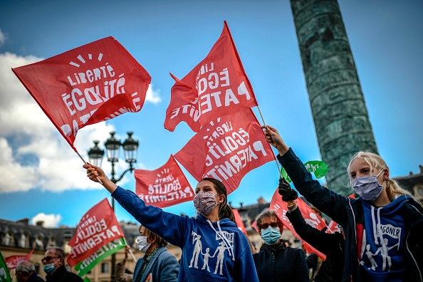 Les opposants au projet de loi sur la bioéthique ont manifesté dans de nombreuses villes de France avec des drapeaux rouges et verts derrière des banderole « privés de papa, de quel droit ».  (Photo STEPHANE DE SAKUTIN/AFP via Getty Images)