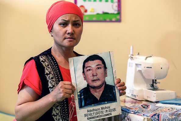 -Bikamal Kaken pose avec un portrait de son mari disparu Adilgazy Muqai, dans la ville provinciale d'Uzynagash, le 27 août 2020. Photo par Abduaziz Madyarov / AFP via Getty Images.