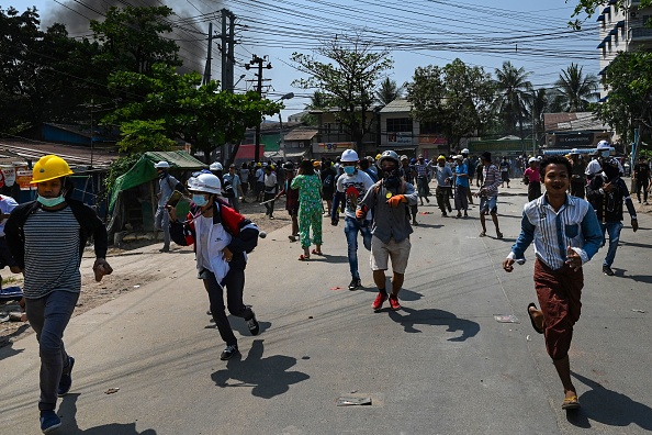 -Des manifestants courent lors d'une répression par les forces de sécurité à Yangon le 19 mars 2021. Photo de STR / AFP via Getty Images.