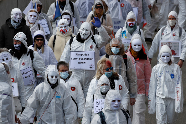 Des manifestants vêtus de blanc participent à une manifestation contre les restrictions actuelles liées à la pandémie du Covid-19 à Liestal, près de Bâle, le 20 mars 2021. (Photo : STEFAN WERMUTH/AFP via Getty Images)