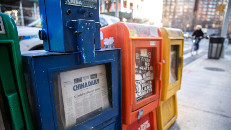 Une boîte à journaux du China Daily se trouve avec d'autres quotidiens gratuits à New York, le 20 janvier 2021. (Chung I Ho/The Epoch Times)
