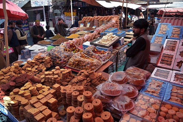 -Les Afghans achètent des fruits secs et des biscuits avant le festival de l'Aïd al-Fitr, qui marque la fin du mois du Ramadan, sur un marché de Kaboul le 12 mai 2021. Photo de WAKIL KOHSAR) / AFP via Getty Images.