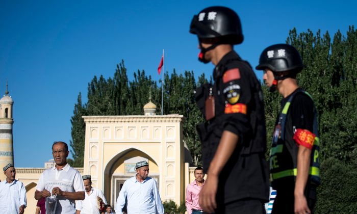 La police patrouille dans les rues alors que des Ouïghours quittent la mosquée Id Kah dans la vieille ville de Kashgar au Xinjiang, le 26 juin 2017. (Johannes Eisele/AFP/Getty Images)