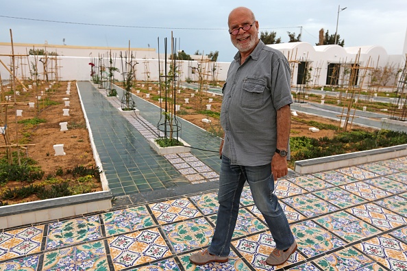 -L'artiste algérien Rachid Koraichi au « Jardin d'Afrique », un cimetière dans le sud de la Tunisie pour les migrants qui se sont noyés en traversant la Méditerranée le 1er juin 2021. Photo de FATHI NASRI / AFP via Getty Images.