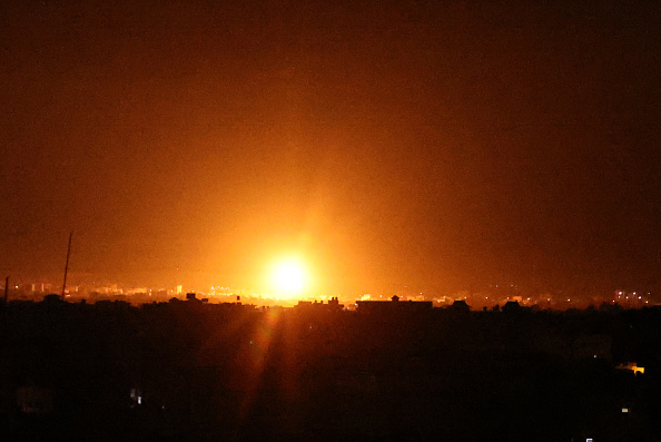 -Des explosions illuminent le ciel nocturne de Khan Yunis dans le sud de la bande de Gaza, les forces israéliennes bombardent l'enclave palestinienne, tôt le 16 juin 2021. Photo de SAID KHATIB / AFP via Getty Images.