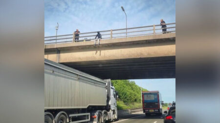 Un homme est vu en haut d’un pont autoroutier. Un chauffeur de camion se gare sous lui pour lui sauver la vie