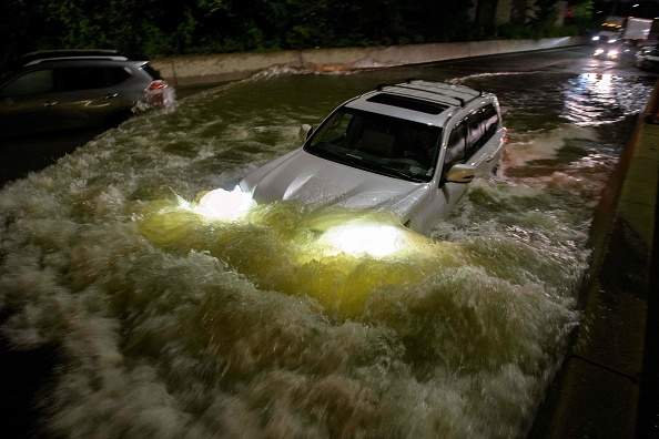 -Un automobiliste conduit une voiture sur une autoroute inondée à Brooklyn, New York, tôt le 2 septembre 2021, Photo par Ed JONES / AFP via Getty Images.