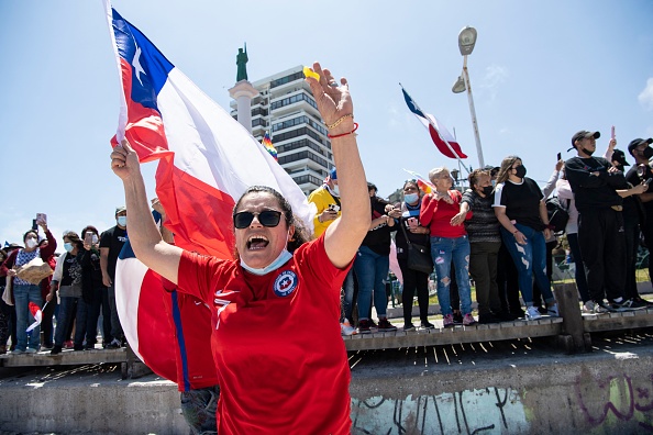 Des personnes brandissant des drapeaux nationaux chiliens protestent contre la migration illégale à Iquique, au Chili, le 25 septembre 2021. (Photo : MARTIN BERNETTI/AFP via Getty Images)