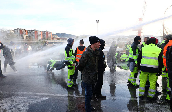 La police utilise des canons à eau contre des dockers venus manifester contre le pass sanitaire le 18 octobre 2021 à Trieste en Italie. (Photo STRINGER/ANSA/AFP via Getty Images)