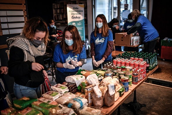 Des bénévoles distribuent de la nourriture à des étudiants dans le besoin lors d'une opération de distribution alimentaire menée par l'association Linkee  (STEPHANE DE SAKUTIN/AFP via Getty Images)