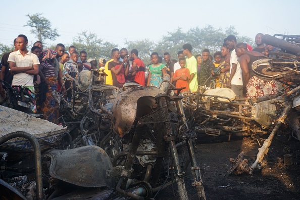 -Les gens regardent un tas de motos brûlées à la suite de l'explosion d'un camion-citerne à Freetown le 6 novembre 2021. Photo par Saidu BAH/AFP via Getty Images.