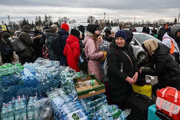 Des réfugiés de différentes nations ramassent des vivres au poste frontière polono-ukrainien, le 28 février 2022 à Medyka, en Pologne. (Photo : Omar Marques/Getty Images)