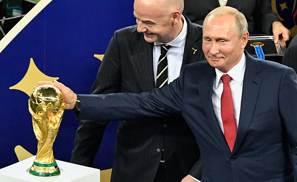Le Président russe Vladimir Poutine aux côtés du président de la FIFA Gianni Infantino lors de la cérémonie de remise des trophées à la fin du match de la finale de la Coupe du monde de football Russie 2018. (Photo : ALEXANDER NEMENOV/AFP via Getty Images)