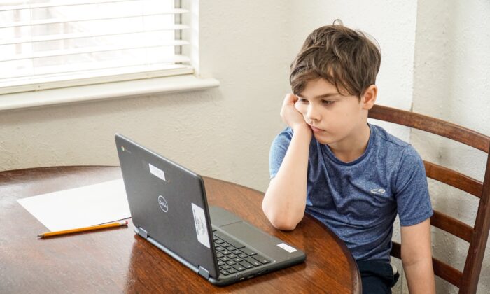 Un garçons devant un ordinateur portable. (Parc Thomas/Unsplash)