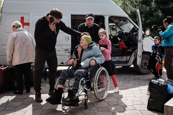 L'aumônier Oleg accueille Kateryna, 94 ans, qui a été évacuée avec d'autres, au centre caritatif géré par l'église pentecôtiste, dans l'est de l'Ukraine, le 4 mai 2022. Photo de YASUYOSHI CHIBA/AFP via Getty Images.