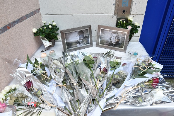 Cette photographie prise le 7 juillet 2022 montre les portraits de Gabriel Fourmigue et Aurélie Pardon, deux enseignants tués le 5 juillet, exposés parmi des fleurs à l'entrée du collège Desaix à Tarbes, dans le sud-ouest.
 (Photo by BASTIEN ARBERET/AFP via Getty Images)