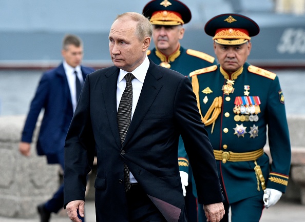 Le président russe Vladimir Poutine (à gauche), suivi du ministre russe de la Défense Sergei Choïgou (à droite), participe à la principale parade navale marquant la Journée de la marine russe, à Saint-Pétersbourg, le 31 juillet 2022. (Photo : OLGA MALTSEVA/AFP via Getty Images)