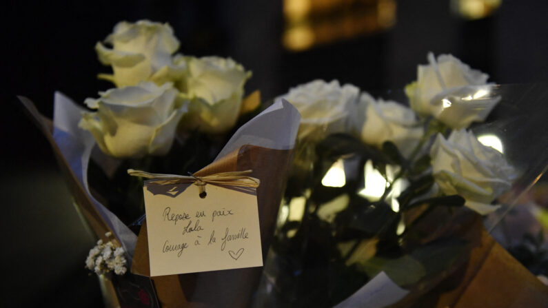 Un bouquet de fleurs et un message "Repose en paix Lola, pensées à la famille" au pied de l'immeuble de Lola, 12 ans, retrouvée morte la veille dans une malle dans le 19e arrondissement de Paris, le 15 octobre 2022. (Photo par JULIEN DE ROSA/AFP via Getty Images)