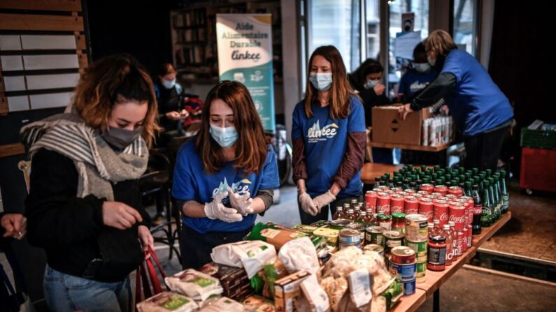 Des bénévoles distribuent de la nourriture à des étudiants dans le besoin lors d'une opération de distribution alimentaire menée par l'association Linkee, à Paris, le 9 mars 2021. (Photo: STEPHANE DE SAKUTIN/AFP via Getty Images)