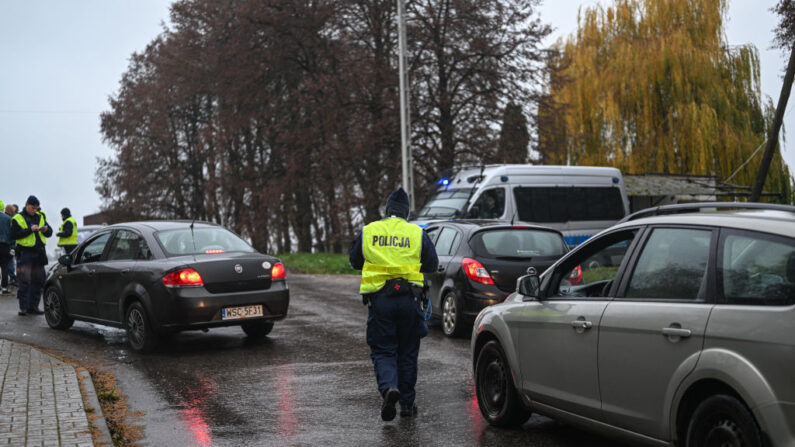Des policiers vérifient les documents des conducteurs à un point de contrôle, alors que seules les voitures autorisées peuvent entrer dans la zone d'explosion, le 16 novembre 2022 à Przewodow, en Pologne.(Photo: Omar Marques/Getty Images)
