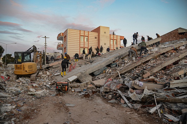 Des habitants et des secouristes à la recherche de victimes et de survivants dans les décombres de bâtiments effondrés à Adiyaman. (Photo : ILYAS AKENGIN/AFP via Getty Images)