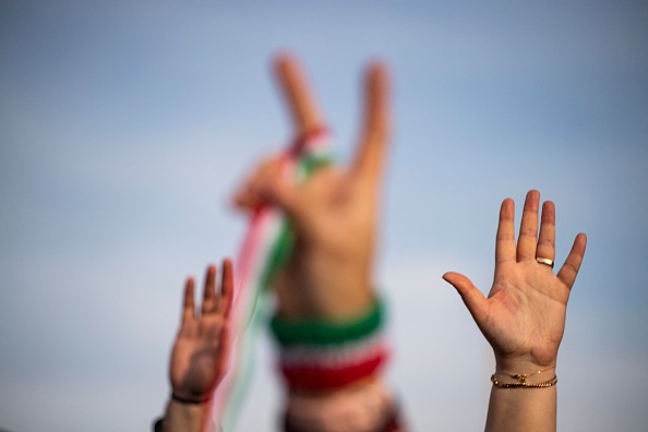 Des personnes lèvent la main lors d'une manifestation pour dénoncer le gouvernement iranien en février 2022. (ROBERTO SCHMIDT/AFP via Getty Images)