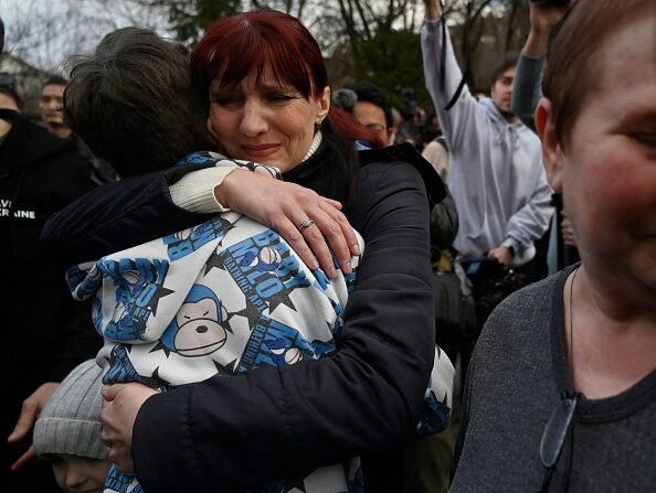 Inessa serre son fils Vitaly dans ses bras après l'arrivée à Kiev, le 22 mars 2023. (SERGEI CHUZAVKOV/AFP via Getty Images)