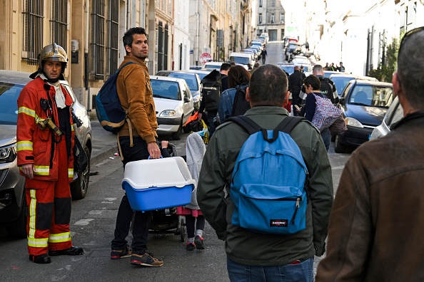 Des habitants de la rue Tivoli sont évacués après l'effondrement d'un immeuble dans la même rue, à Marseille. (NICOLAS TUCAT/AFP via Getty Images)