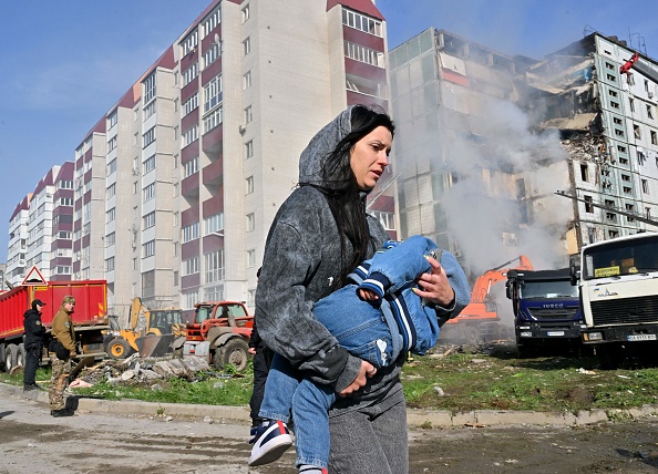 Une femme passe devant des bâtiments résidentiels endommagés après que des frappes de missiles russes ont visé plusieurs villes ukrainiennes pendant la nuit du 28 avril 2023. (SERGEI SUPINSKY/AFP via Getty Images)