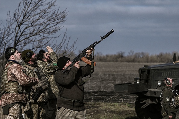 Un soldat ukrainien tire avec son fusil sur un drone volant au-dessus de leur position près de Bakhmut le 20 mars 2023. (ARIS MESSINIS/AFP via Getty Images)
