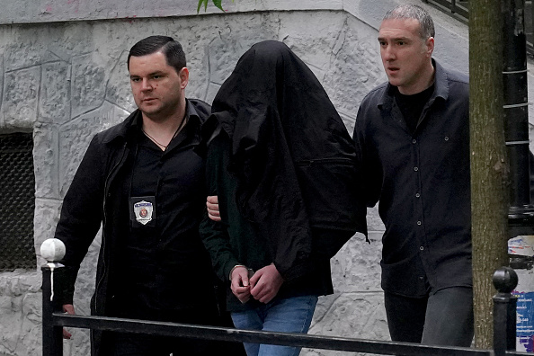Des policiers escortent un élève soupçonné d'avoir tiré plusieurs coups de feu dans une école, à Belgrade, le 3 mai 2023. (OLIVER BUNIC/AFP via Getty Images)