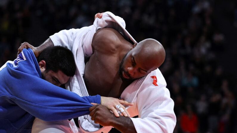 Le Français Teddy Riner (blanc) et l'Azerbaïdjanais Dzhamal Gamzatkhanov, lors de leur combat de quart de finale dans la catégorie des +100kg au tournoi de judo Paris Grand Slam à Paris le 5 février 2023. (Photo by ANNE-CHRISTINE POUJOULAT/AFP via Getty Images)