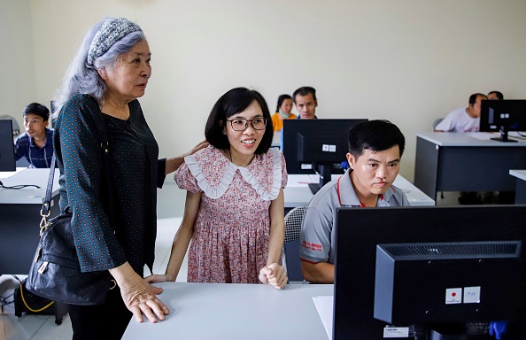 Tran To Nga (à g.) dans une classe d'informatique au centre de Hanoi pour les victimes de la dioxine de l'agent orange, en mai 2023. (NAM NGUYEN/AFP via Getty Images)