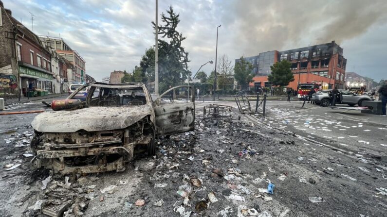 Le 30 juin 2023, un véhicule incendié se trouve dans une rue devant l'immeuble du groupe Tessi, dans le quartier de l'Alma à Roubaix. (Photo DENIS CHARLET/AFP via Getty Images)