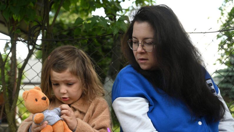Kateryna Skopina regarde sa fille Anna-Maria 6 ans, dans le village d'Ivano-Frankove à environ 40 km de la ville de Lviv, le 3 juin 2023. (Photo YURIY DYACHYSHYN/AFP via Getty Images).