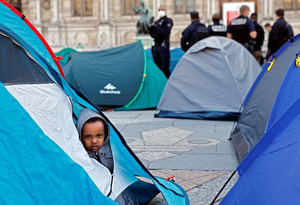 Un enfant assis dans une tente regarde les migrants évacués en 2020. (Photo THOMAS COEX/AFP via Getty Images)